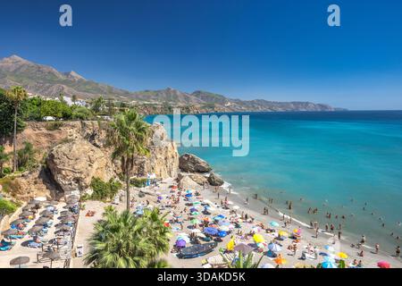 Nerja, Spagna - 9 settembre 2024: Vista da piazza Balcon de Europa. Spiaggia affollata con acque turchesi e scogliere spettacolari. Foto Stock