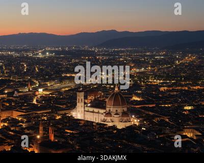 Vista aerea di Firenze al tramonto con la Cattedrale di Santa Maria del Fiore illuminata nel centro storico della città, Toscana, Italia Foto Stock