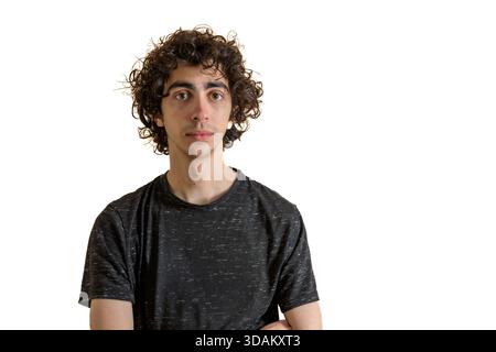 Giovane uomo con capelli ricci in piedi su uno sfondo bianco. Foto Stock
