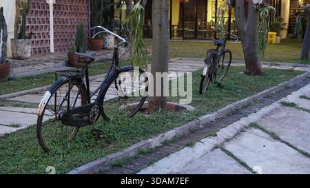 un'antica bicicletta nera situata nel giardino come struttura decorativa Foto Stock