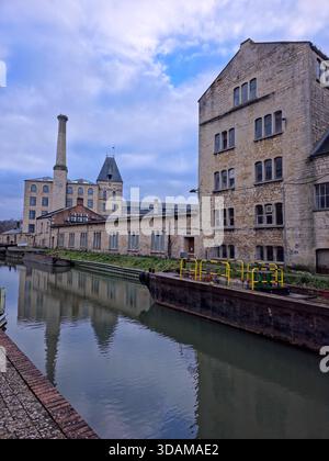 Storico mulino Ebley (Stroud Mill) con alti camini e edifici industriali sul canale che si riflettono nel tranquillo canale Stroudwater in una giornata invernale, Foto Stock
