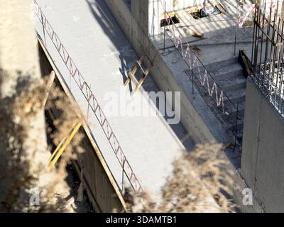 Vista di una struttura in cemento in costruzione con rinforzo in metallo e una tavola in legno, vista dal piano terra, Istanbul, Istanbul, Turkiye. Foto Stock