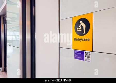 Londra, Regno Unito, novembre 25 2025: Cartello giallo per il cambio dei bambini con pittogramma e codice qr in un aeroporto Foto Stock