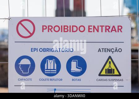 Cartello di sicurezza per cantieri che mostra proibido entrar e dpi obbligatori in portoghese Foto Stock