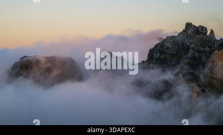 Alba a Pico do Arieiro, nuvole di nebbia si estendono sulle vette delle montagne, mare di nebbia, sentiero escursionistico PR1, Madeira, Portogallo Foto Stock