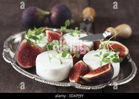 Cibo, fichi e formaggio di capra su Una piastra di metallo Foto Stock