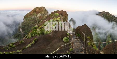 Alba a Pico do Arieiro, nuvole di nebbia si estendono sulle vette delle montagne, mare di nebbia, sentiero escursionistico PR1, Madeira, Portogallo Foto Stock