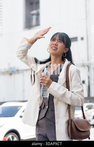 Donna di viaggio persona in città per affari di strada lavora all'aperto, proteggendo gli occhi dal sole duro Foto Stock