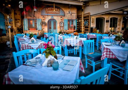 Tavoli da pranzo all'aperto presso la Taverna Amphora nella città vecchia di Chania, Creta, Grecia, con decor tradizionale e atmosfera serale. Foto Stock