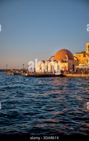 Vista dell'ora d'oro del porto veneziano e della moschea di Hassan Pasha lungo il lungomare di Chania, Creta. Foto Stock