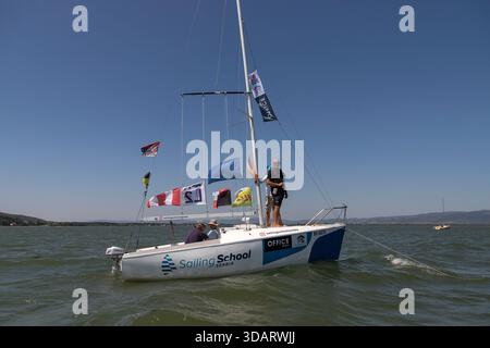 I giudici della barca del comitato di gara monitorano la regata del campionato nazionale Optimist e ILCA 6 sul Danubio vicino a Golubac, in Serbia. Foto Stock