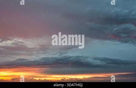 Serena atmosfera crepuscolare con luce e nuvole che fluttuano nel magico bagliore del sole che tramonta. Un momento davvero bello e tranquillo. Foto Stock