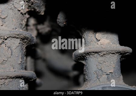 Una vista ravvicinata mostra le parti dei macchinari ricoperte di polvere in un'officina. L'immagine cattura l'accumulo di sporcizia sulle superfici delle apparecchiature in condizioni di Foto Stock