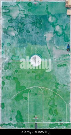 Vista aerea del campo da basket con vernice bianca e verde chiazzata, che crea una superficie strutturata sotto il sole delle Bahamas, Alice Town, Bimini, The Ba Foto Stock