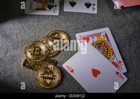Gettoni bitcoin dorati e carte da gioco che rappresentano gioco d'azzardo, rischio e giochi da casinò online Foto Stock