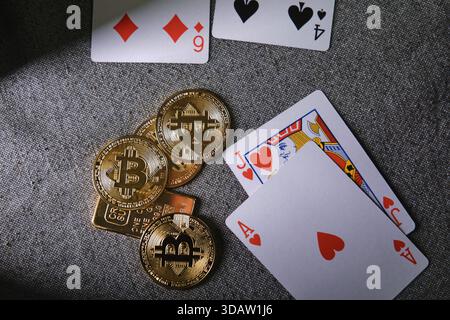 Gettoni bitcoin dorati e carte da gioco che rappresentano gioco d'azzardo, rischio e giochi da casinò online Foto Stock