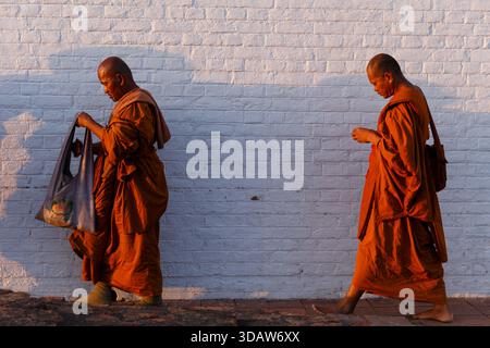 Monaci buddisti che camminano lungo un muro bianco a Lumbini, Nepal, durante una cerimonia religiosa nel luogo di nascita del Buddha il 10 marzo 2015. Foto Stock
