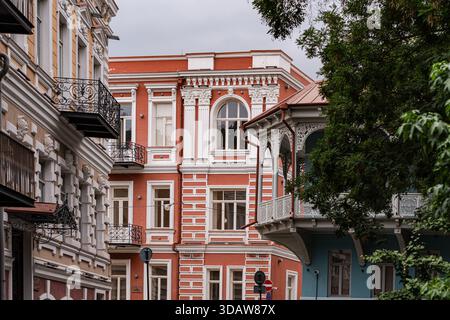 Un intricato fascino di Tiflis, Georgia, attraverso i suoi eleganti edifici storici. Caratterizzato da facciate ornate, balconi e vegetazione lussureggiante, questo scenario è perfetto Foto Stock