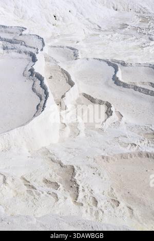 Una vista mozzafiato delle terrazze naturali in travertino di Pamukkale in Turchia, che mostrano strati di formazioni minerali bianche. Questo sito patrimonio dell'umanità dell'UNESCO Foto Stock