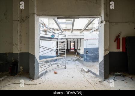 L'area industriale è in fase di ristrutturazione e presenta impalcature esposte e materiali da costruzione sparsi. Il sito mostra i progressi visibili Foto Stock