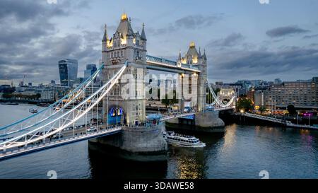 Vista aerea del Tower Bridge di Londra durante il crepuscolo, che mostra l'iconico skyline, tra cui l'edificio Walkie Talkie e le vivaci luci del paesaggio urbano Foto Stock