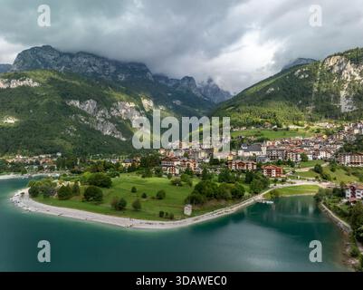 Vista aerea di un pittoresco villaggio immerso nel verde lussureggiante delle Dolomiti. L'immagine cattura la bellezza serena delle montagne e un tranquillo Foto Stock