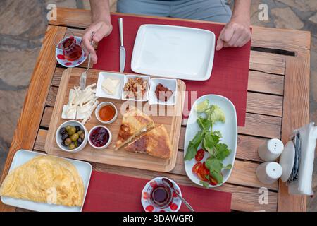 Colazione tradizionale turca con pane fresco, olive, formaggio, pomodori, cetrioli, e varietà di inceppamenti e spalmazioni. Godibile in un ambiente vivace Foto Stock