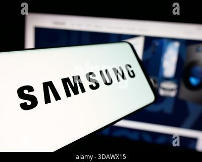 Stoccarda, Germania - 12-02-2025: Smartphone con logo della società coreana Samsung Electronics Co. Ltd. Sullo schermo davanti al sito Web. Foto Stock