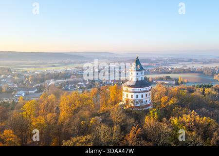 L'elegante castello di caccia barocco Humprecht sorge sopra Sobotka, circondato da un vivace fogliame autunnale, illuminato dalla luce soffusa di un'alba tranquilla. Foto Stock