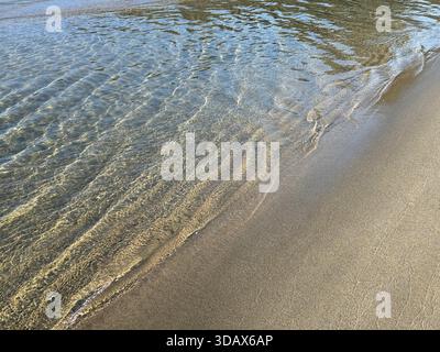 Onde di mare sulla spiaggia di sabbia Foto Stock