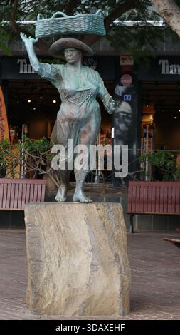 La statua di Muelle Pesquero a Los Christianos. Opera dello scultore Julio Neto, raffigura una donna che trasporta il pesce in un cesto sulla sua testa. Foto Stock