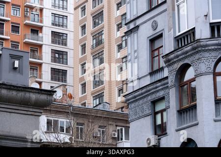 Vari edifici si incontrano in città, mostrando stili architettonici vecchi e nuovi. Kiev, Ucraina. 12 dicembre 2025. Foto Stock