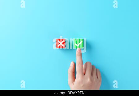 Concetto decisionale. Una persona sceglie tra i blocchi di X rossa e di segno di spunta verde, accetta e rifiuta, vero e falso, sì o no, valutazione, votazioni, Foto Stock