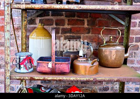 Bollitori vintage e decorazioni su scaffali rustici in mattoni Foto Stock