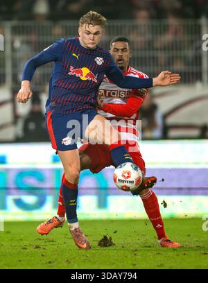 Berlino, Germania. 13 dicembre 2025. Calcio: Bundesliga, 1. FC Union Berlin - RB Leipzig, Matchday 14, an der Alten Försterei, Conrad Harder (l, RB Leipzig) contro Danilho Doekhi (1. FC Union Berlin). Credito: Soeren Stache/dpa - NOTA IMPORTANTE: In conformità con le normative della DFL German Football League e della DFB German Football Association, è vietato utilizzare o far utilizzare fotografie scattate nello stadio e/o della partita sotto forma di immagini sequenziali e/o serie di foto video./dpa/Alamy Live News Foto Stock
