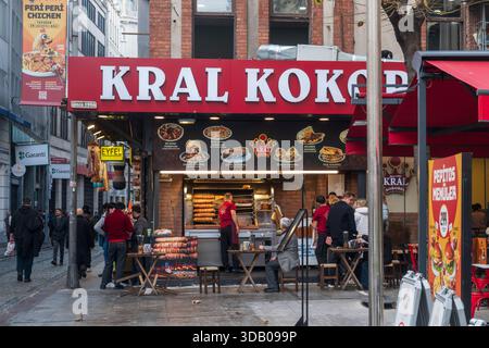 Famoso ristorante di Street food Kral Kokorej con clienti che mangiano cucina tradizionale turca e pedoni sulla strada trafficata di Eminönü Istanbul Turchia Foto Stock