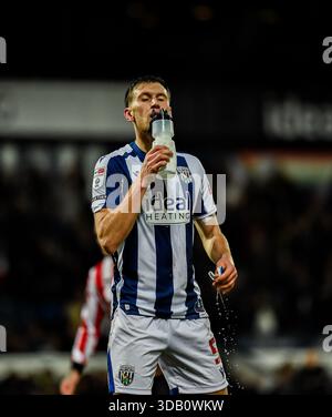 West Bromwich Albion centrocampista, Krystian Bielik, bevendo un drink durante una pausa in gioco. Foto Stock