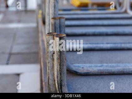 Primo piano di tubi metallici arrugginiti sul tetto urbano con sfondo sfocato. Foto Stock