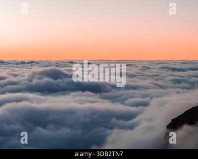 Alba color pastello sul mare nuvoloso dal punto panoramico delle alte vette di Madeira Foto Stock