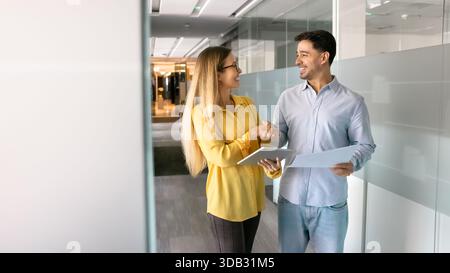 Positivo giovane latino professionista che dà stretta di mano a esperto Foto Stock
