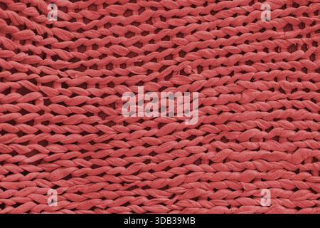 Macro, primo piano, tessuto a maglia rosso dettagliato, texture del tessuto con motivo a filo grosso. Intimo sfondo di stoffa fatta a mano, sfondo di maglieria, per Foto Stock