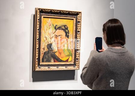 New York, Stati Uniti. 13 dicembre 2025. Un visitatore scatta una foto di Frida Kahlo Autorretrato con chango y loro venduta per più di 3 milioni di dollari durante l'anteprima stampa alle mostre Sotheby's 'Icons' e Bing Crosby di New York, NY il 13 dicembre 2025. Crediti: lev radin/Alamy Live News Foto Stock