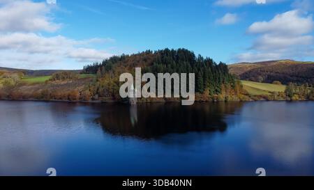 Vista aerea della torre vittoriana sul lago Vyrnwy, circondata da boschi autunnali e riflessa nelle calme acque del bacino idrico Foto Stock