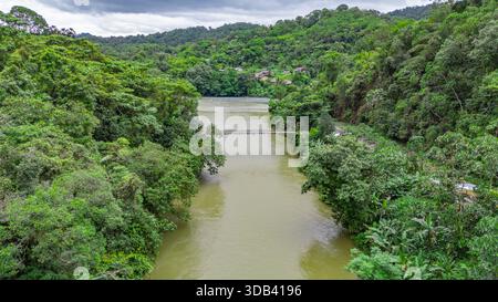 Un tranquillo fiume scorre attraverso un fitto paesaggio verde ad Agua Clara, Valle del Cauca, Colombia, che mostra la bellezza e la serenità della natura. Foto Stock