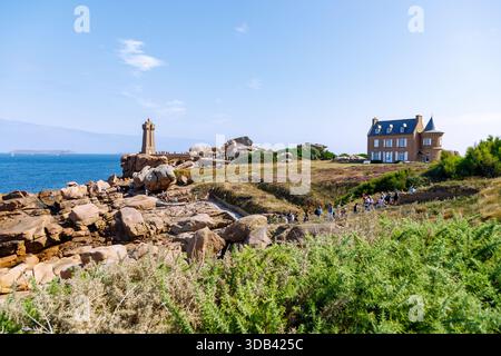 Cote de Granit Rose con faro Phare de Mean Ruz e casa tra le formazioni rocciose dei doganieri' percorso (Sentier des Douaniers) Foto Stock