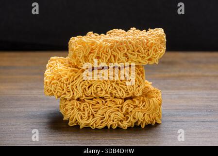 Vista ravvicinata degli spaghetti istantanei essiccati sul tavolo di legno Foto Stock