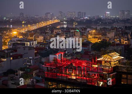 Vista dal bar sul tetto dello Skyline Lounge dell'Hanoi Tirant Hotel al tramonto, affacciato sui tetti degli edifici del quartiere Vecchio, Hanoi e Hanoi Cap Foto Stock