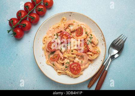 Linguine di pesce in salsa cremosa con gamberi e pomodori Foto Stock