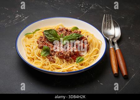 Spaghetti alla bolognese con basilico e parmigiano grattugiato Foto Stock