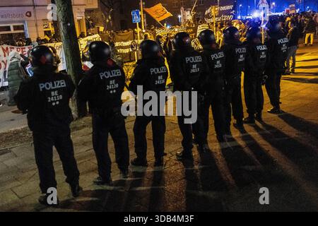 Berlino, Germania. 13 dicembre 2025. Gli agenti di polizia sono visibili in primo piano sullo sfondo di manifestanti durante una dimostrazione da parte di gruppi di sinistra contro la polizia nel distretto di Friedrichshain mentre la polizia protegge l'area. La manifestazione si è svolta durante l'annuale manifestazione anti-polizia a Friedrichshain (spesso indicato come ACAB Day) di Berlino. I partecipanti protestavano contro le pratiche di polizia e le forze dell'ordine in generale, e parte della manifestazione includeva anche slogan e messaggi filo-palestinesi. Credito: SOPA Images Limited/Alamy Live News Foto Stock